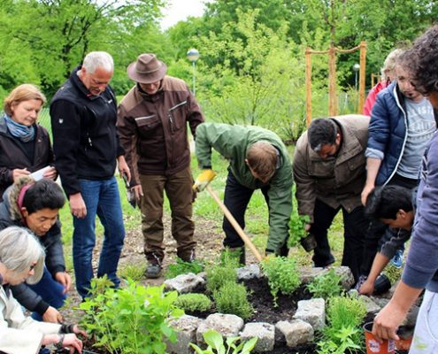 Integration durch gemeinsame Gartenarbeit: Beim Anlegen einer Kräuterschnecke geht's auch ums Miteinander.