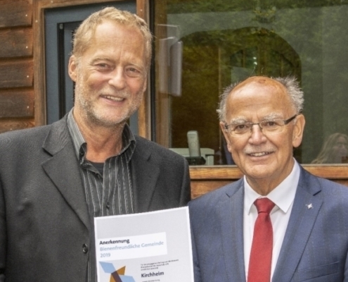 Bienenfreundliche Gemeinde: Gerd Kleiber, Dritter Bürgermeister von Kirchheim, nimmt die Anerkennungsurkunde aus den Händen von Bezirkstagspräsident Josef Mederer (rechts) entgegen. Foto: Wolfgang Englmaier