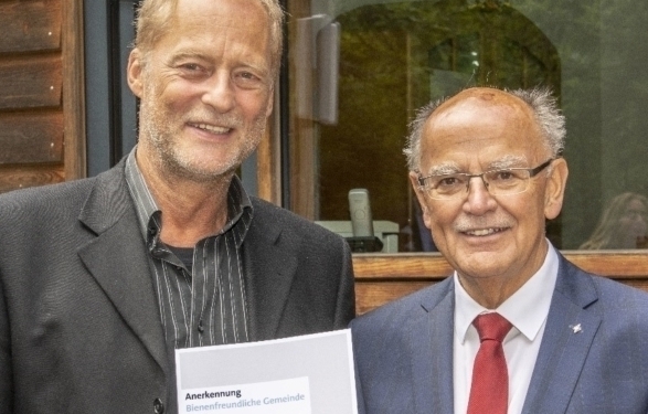 Bienenfreundliche Gemeinde: Gerd Kleiber, Dritter Bürgermeister von Kirchheim, nimmt die Anerkennungsurkunde aus den Händen von Bezirkstagspräsident Josef Mederer (rechts) entgegen. Foto: Wolfgang Englmaier