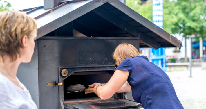 Schieb, schieb in den Ofen rein: Gemeinsames Brotbacken auf dem Pfarrer-Caspar-Mayr-Platz verbindet, schafft ein Gemeinschaftsgefühl und zeugt von einem lebendigen Ortskern. Foto: Claudia Topel