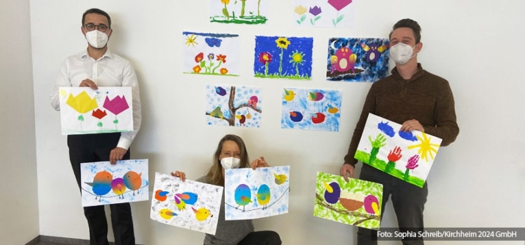 Machen super Frühlingslaune: Die Bilder der Kinder vom Haus Am Schlehenring zum Thema „Vögel“ und „Der Frühling kommt“. Das Team der Kirchheim 2024 GmbH (auf dem Foto v.l. Johannes Pinzel, Geschäftsführer; Dr. Gerda Hausladen, Assistenz der Geschäftsführung; Armin Wandschura, Technischer Leiter) bedankt sich herzlich für die Bilder.